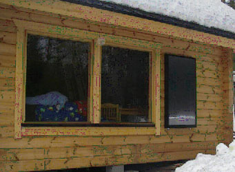 Enean-mökkilämmitin asennettuna hirsimökkiin...